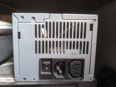 The old power supply after it died. (The unplugged fan and the missing screws do not resemble how it looked while it was in use.)
