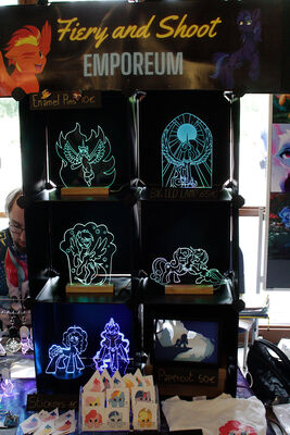 Folr the first time there was a vendor at GalaCon who mainly sold similar items as me_ He has laser-cut and -etched vectors, a limited slection of pictures, a nice table set-up with black backgrounds, just one type of base_ Nice work_ A more professional-looking version of my table_ But a smaller selection of characters as well_